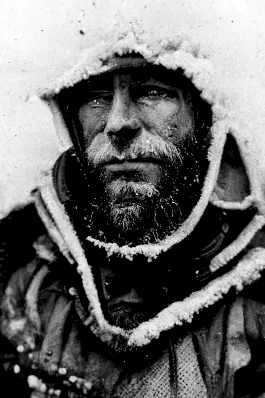 Antarctica 2-3 Prompt: an old grainy black and white photo portrait of an arctic explorer tired beard covered in ice expedition gear hood frost bitten nose and cheeks close up dramatic